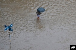 A person wades through a flooded street after a storm in Bahia Blanca, Argentina, March 7, 2025.