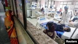 A woman looks into the intensive care unit (ICU) at the Baba Raghav Das hospital in the Gorakhpur district, India, Aug. 14, 2017. 