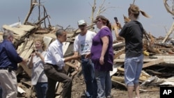 President Barack Obama, third from left, talks with residents while viewing damage from the tornado that devastated Joplin, Mo., Sunday, May 29, 2011.