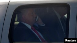 FILE - President-elect Donald Trump, at the time still the Republican presidential nominee, talks on his phone as he is driven to his at a campaign rally in Scranton, Pennsylvania, July 27, 2016.