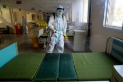 A worker in protective suit disinfects the Wuhan No. 7 Hospital, once a designated hospital for the COVID-19 patients, to prepare it for the resumption of its normal service in Wuhan, Hubei province, China, March 19, 2020.