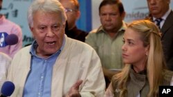 Spain's former prime minister Felipe Gonzalez, speaks to reporters as Lilian Tintori wife of jailed opposition leader Leopoldo Lopez looks at him during a press conference at the headquarters of Movement of Democratic Unity (MUD) opposition coalition in Caracas, Venezuela, June 8, 2015.