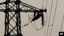 In this Saturday, Feb. 8, 2014 photo, linemen are silhouetted as they work to restore electrical power, at an electric pole in Krang Thnong at the outskirt of Phnom Penh, Cambodia. (AP Photo/Heng Sinith)