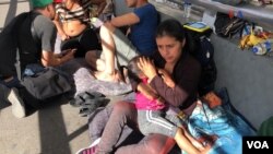 Migrantes de Guatemala, Cuba, Honduras y El Salvador hacen fila en el Puente Internacional de Santa Fe, El Paso en Texas, para solicitar asilo político en Estados Unidos.