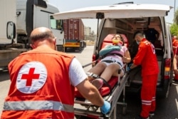 Lebanese Red Cross volunteers help an injured anti-government protester during scuffles between protesters and riot police at the Ministry of Energy and Water, in Beirut, Lebanon, May 21, 2020.