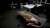 FILE - A worker sleeps in the office after finishing work early morning, in Beijing, China, April 27, 2016. (REUTERS/Jason Lee)