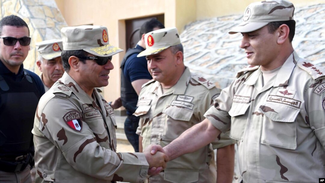 In this picture provided by the office of the Egyptian Presidency, Egyptian President Abdel Fattah el-Sisi, second left, greets members of the Egyptian armed forces in Northern Sinai, Egypt, July 4, 2015.