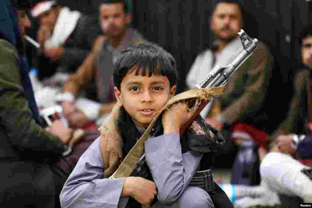 A boy holds a rifle as he attends a rally of Houthi movement supporters to mark the Ashura in Sana&#39;a, Yemen.