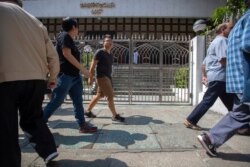 Pedestrians walk past a blue-stained sidewalk outside the Kowloon Mosque a day after it was sprayed with blue-dyed water by a police riot-control vehicle in Hong Kong, Oct. 21, 2019.