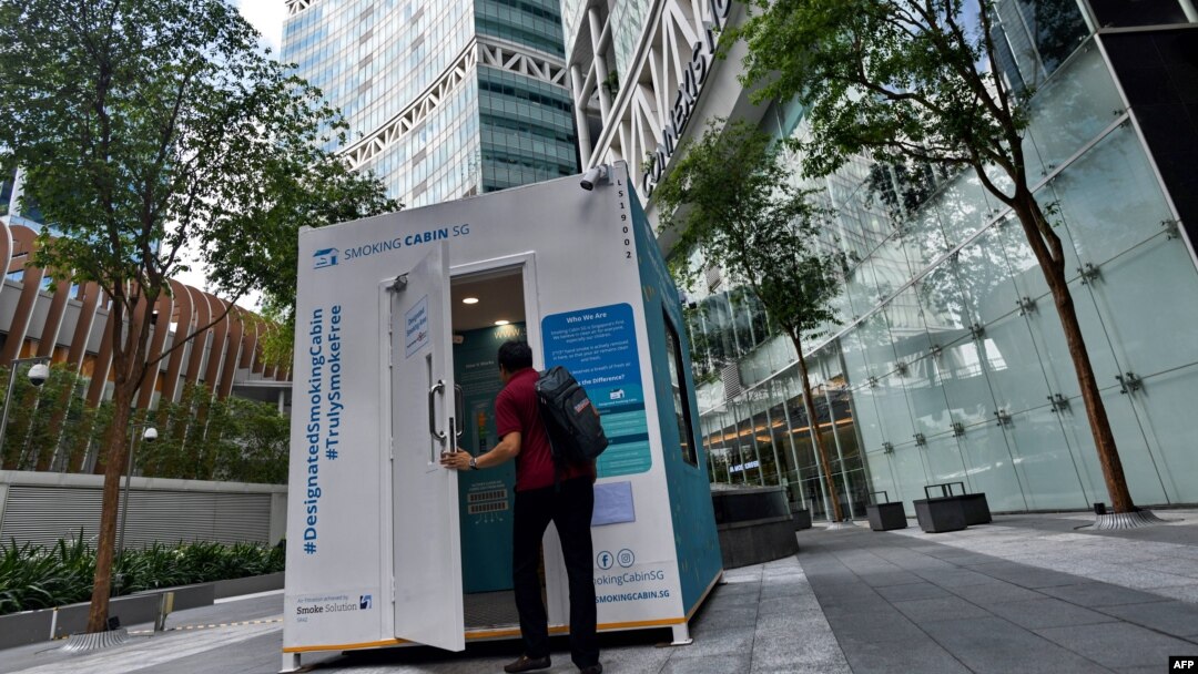Seorang pria memasuki pondok merokok yang dikembangkan oleh Southern Globe Corporation (SGC), di luar gedung perkantoran di Singapura, 22 Mei 2019. (Foto: Roslan RAHMAN / AFP)