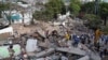 A drone view shows rescuers searching for survivors amid destroyed buildings following an earthquake, in Cali, Colombia, August 12, 2026. 