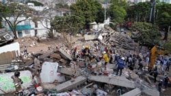 A drone view shows rescuers searching for survivors amid destroyed buildings following an earthquake, in Cali, Colombia, August 12, 2026. 