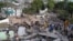 A drone view shows rescuers searching for survivors amid destroyed buildings following an earthquake, in Cali, Colombia, August 12, 2026. 