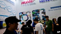 FILE - Visitors are seen at a social network company booth at the 2016 Global Mobile Internet Conference (GMIC) in Beijing, China, April 28, 2016. Last year, China passed a cybersecurity law that foreign companies say might isolate Chinese industries.