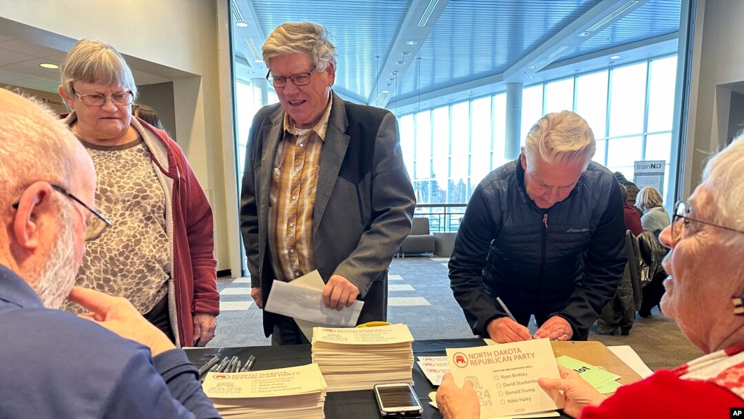 Claus, left, and Marsha Lembke, right, handle ballots for Republican caucus voters on March 4, 2024, at Bismarck State College in Bismarck, N.D. The college is one of 12 sites for the North Dakota Republican caucuses.