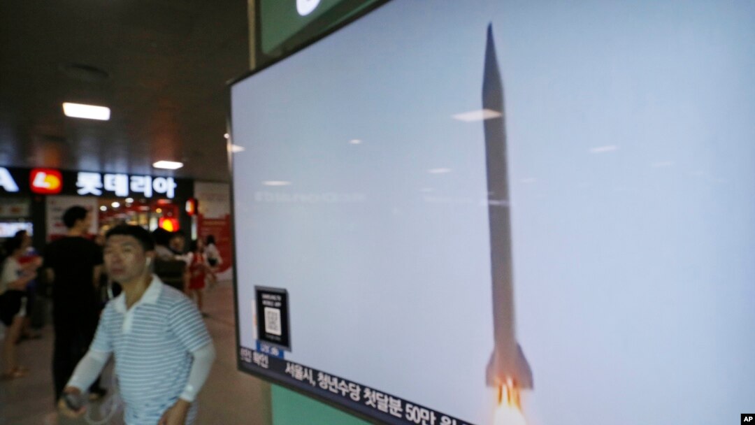 Seorang pria melewati TV yang menunjukkan gambar misil Korea Utara di stasiun kereta Seoul, Korea Selatan Rabu (3/8).