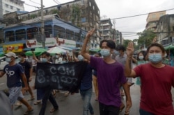 Anti-coup protesters flash the three-finger salute during a demonstration against the military takeover, in Yangon, Myanmar, May 24, 2021.