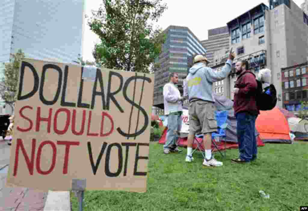 Demonstrators talk near their tents in the Occupy Boston encampment on the Rose Kennedy Greenway across the street from the Federal Reserve building, in Boston, Sunday, Oct. 2, 2011. The group is part of a nationwide grassroots movement in support of the 