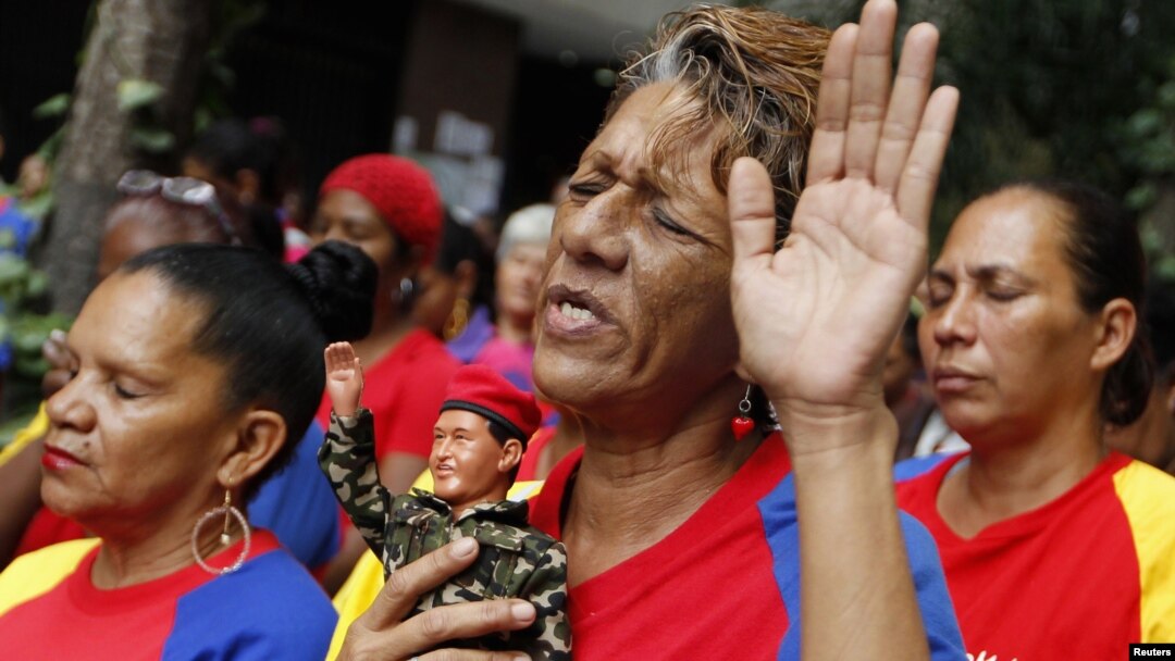 Seorang warga Venezuela memegang boneka Presiden Hugo Chavez dalam doa massal untuk kesehatan Chavez di Caracas. (Foto: Reuters)