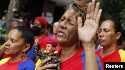 Seorang warga Venezuela memegang boneka Presiden Hugo Chavez dalam doa massal untuk kesehatan Chavez di Caracas. (Foto: Reuters)