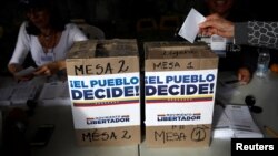 Una mujer emite su voto en el plebiscito contra el gobierno del presidente venezolano Nicolás Maduro, en Caracas, Venzuela, el domingo 16 de julio de 2017.
