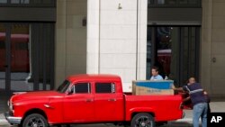 Men load a newly bought refrigerator onto a truck in Havana, Cuba, March 9, 2020. Cuban authorities have started to promote websites that allow people to pay in U.S. dollars through a credit card for items refrigerators.