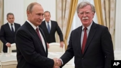 Russian President Vladimir Putin, left, shakes hands with U.S. National security adviser John Bolton during their meeting in the Kremlin in Moscow, Russia, June 27, 2018. 