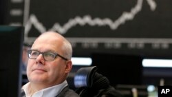 A broker is seen checking his screens at the stock market in Frankfurt, Germany, Jan. 21, 2016.