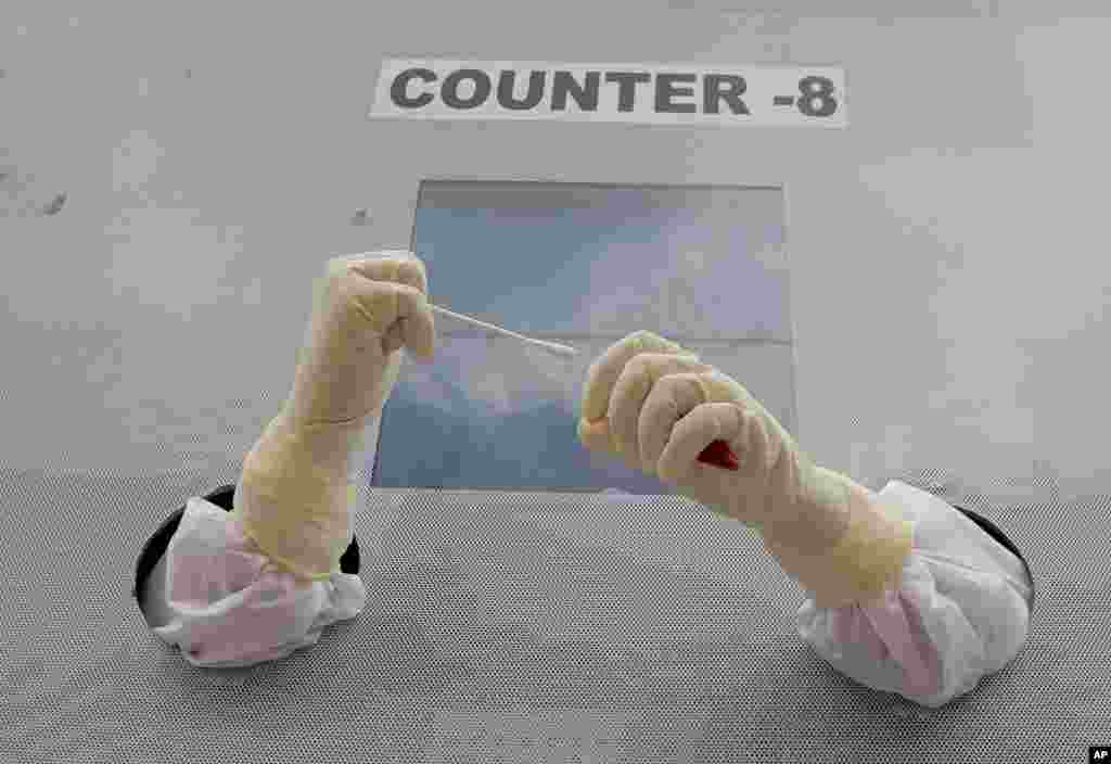 A health worker prepares to collect nasal swab samples for COVID-19 tests at a mobile testing center in Hyderabad, India.