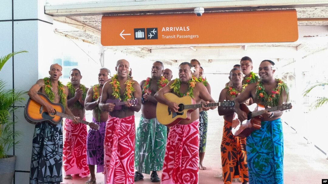 Para tamu disambut dengan penampilan tradisional Fiji saat mereka tiba di bandara internasional Nadi, Fiji, 1 Desember 2021. (Bruce Rounds/Tourism Fiji via AP)