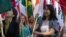 FILE - International students carry their national flags at the University of Missouri in Columbia, Missouri.