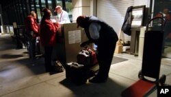 FILE - Travelers use the curb side check-in at Bradley International Airport in Windsor Locks, Connecticut, early morning, Nov. 21, 2007. 