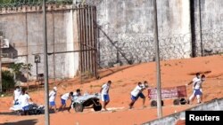 Inmates transport bodies after a prison riot in Natal, Rio Grande do Norte state, Brazil, Jan. 15, 2017. 