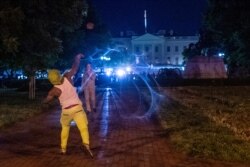 Un manifestante lanza un objeto contra los agentes de seguridad que hacen guardia frente a la Casa Blanca, en el centro de Washington.