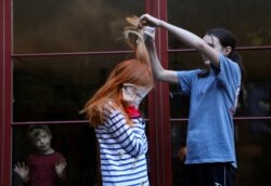 Jane Hassebroek helps her sister Lydia dye her hair for a costume for Halloween at their home, as the coronavirus disease outbreak continues, in New York, Oct. 31, 2020.