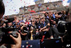 The U.S. women's soccer team celebrates at City Hall after a ticker tape parade, July 10, 2019, in New York.