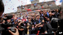 FILE - The U.S. women's soccer team celebrates at City Hall after a ticker tape parade, July 10, 2019, in New York. The team beat the Netherlands 2-0 to capture a record fourth Women's World Cup title. 