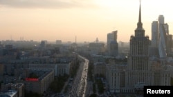 Vehicles move along a road near the buildings of the Moscow International Business Centre (R, back) in Moscow, Sept. 17, 2014.