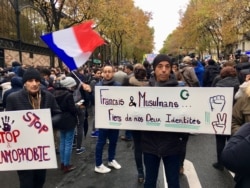 A man (M) carries banner reading, French and Muslims, proud of our identity, Paris, Nov. 10, 2019. (Lisa Bryant/VOA)