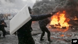 ARHIVA - Učesnik protesta upire pištolj u policiju u Kijevu (Foto: AP/Efrem Lukatsky)