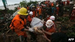 Rescue workers carry the body of a landslide victim in Paung township, Mon state, Aug. 10, 2019. The death toll from a landslide triggered by monsoon rains in eastern Myanmar rose to nearly 50.