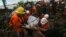 Rescue workers carry the body of a landslide victim in Paung township, Mon state, Aug. 10, 2019. The death toll from a landslide triggered by monsoon rains in eastern Myanmar rose to nearly 50.