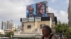 A man walks past a billboard displaying portraits of Hamas leaders Ismail Haniyeh, left, and Mohammed Deif and with the slogan “assassinated” written in Hebrew, in Tel Aviv, Israel, on Aug. 2, 2024.