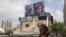 A man walks past a billboard displaying portraits of Hamas leaders Ismail Haniyeh, left, and Mohammed Deif and with the slogan “assassinated” written in Hebrew, in Tel Aviv, Israel, on Aug. 2, 2024.