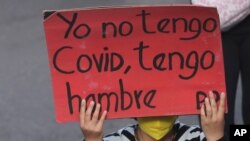 Una mujer sostiene un cartel con la frase "Yo no tengo Covid, tengo hambre" durante una marcha en Quito, Ecuador, el 16 de julio de 2020.