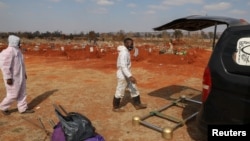 Funeral workers wearing personal protective equipment are seen after a burial South Africa