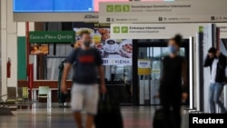 Viajeros con máscaras protectoras son vistos en el Aeropuerto Internacional Presidente Juscelino Kubitschek, en Brasilia, en medio de la propagación de la enfermedad por coronavirus.