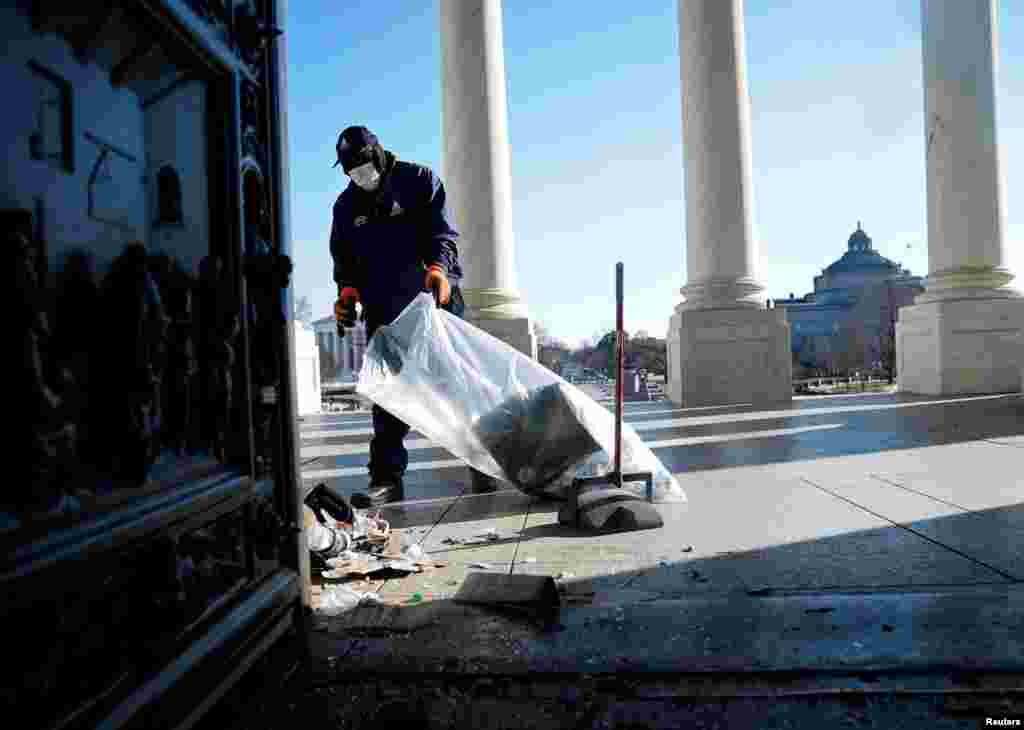 Un trabajador limpia escombros fuera del Capitolio, un d&#237;a despu&#233;s del asalto de seguidores de Trump. 