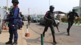 Security personnel take positions as police officers run along the convoy of Nigeria's President Goodluck Jonathan after a People's Democratic Party (PDP) National Executive Council meeting in Abuja, Jan. 16, 2014.