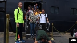 A passenger reacts as he disembarks from the Westerdam cruise ship in Sihanoukville, Cambodia, where the liner docked after being refused entry at other Asian ports due to fears of the COVID-19 coronavirus outbreak.